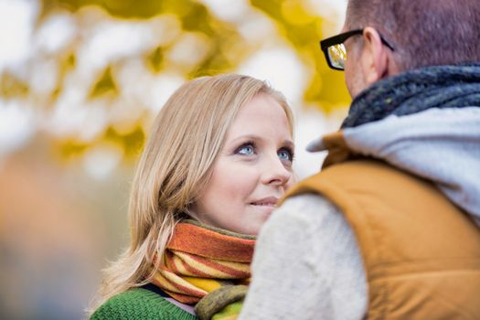 Portrait of beautiful woman showing affection while talking to her husband in park