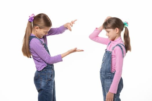 A girl shows a virtual object on her hand, another girl looks at her and scratches her head in bewilderment.