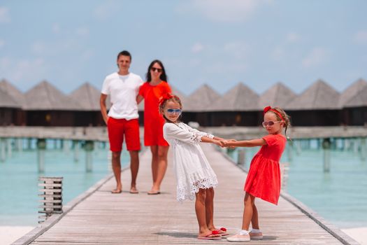 Beautiful happy family have fun on wooden jetty during summer vacation