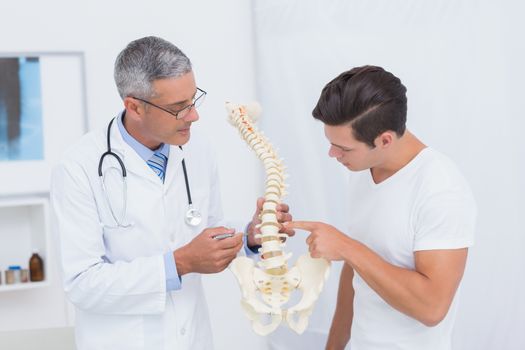 Doctor explaining anatomical spine to his patient 
