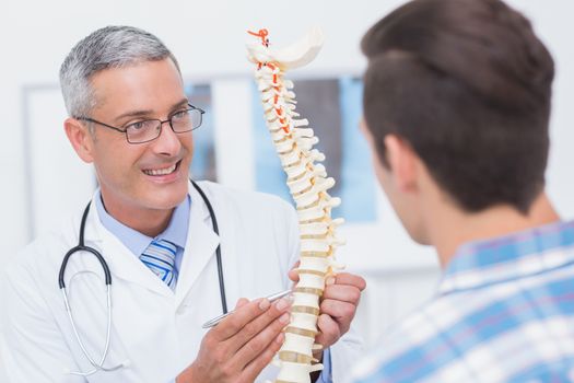 Doctor showing anatomical spine to his patient 