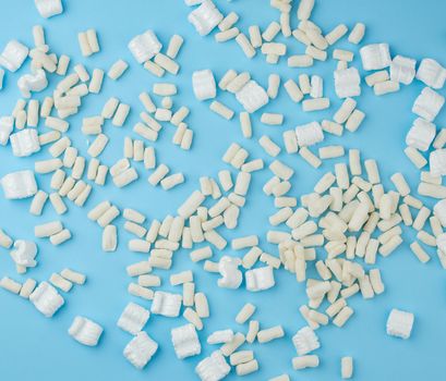 scattered white foam for packaging parcels on a blue background