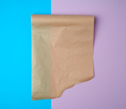 unwrapped a roll of brown parchment paper on a colored backgroun