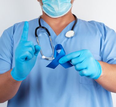 doctor in blue uniform and sterile latex gloves holds a dark blu