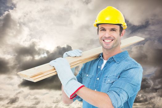Composite image of happy carpenter carrying wooden planks