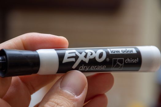 Expo Dry Erase marker, black, with hand holding for whiteboards.