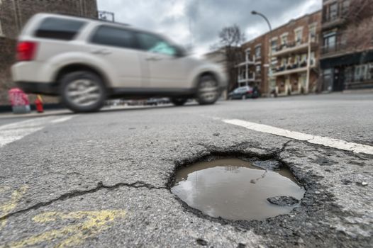 Large unrepaired pothole on Laurier street in Montreal, Canada (