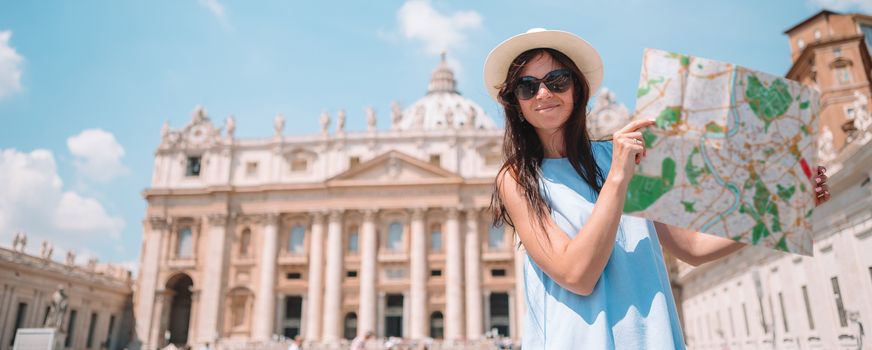 Happy young woman with city map in Vatican city and St. Peter's Basilica church