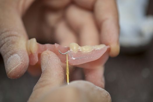 Dental technician work on denture prothesis in dental laboratory