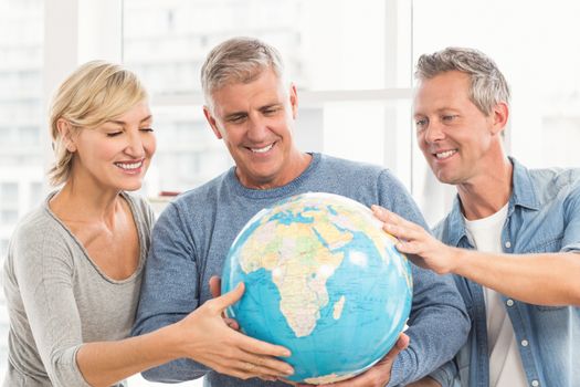 Happy business colleagues holding terrestrial globe