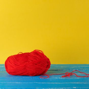 big skein of red wool on a blue background