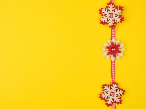 Christmas garland with carved felt snowflakes on a red ribboб