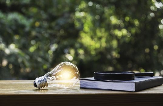Light bulb and a book on table and copy space for insert text.