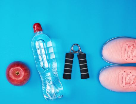 plastic water bottle, red ripe apple and sports expander 