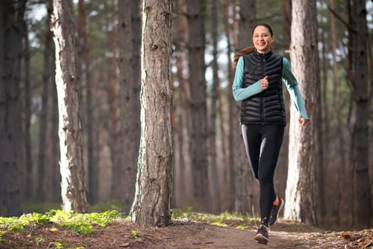 Woman Runner Jogging on the Forest Trail. Sport and Active Lifestyle Concept.
