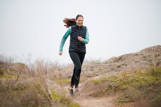 Happy Woman Running on the Mountain Trail. Sport and Active Lifestyle Concept.
