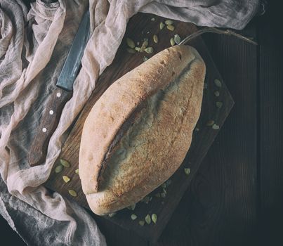 baked crisp oval bread and vintage knife