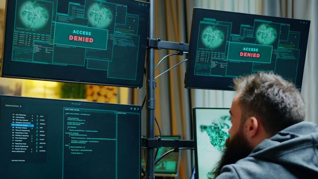 Zoom in shot of male hacker trying to hack a firewall