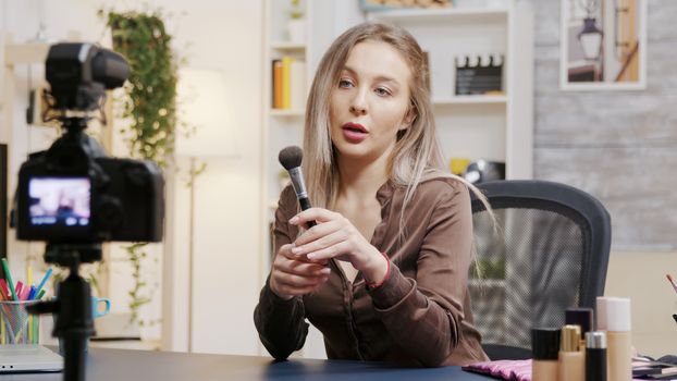 Young beautiful beauty vlogger recording makeup tutorial