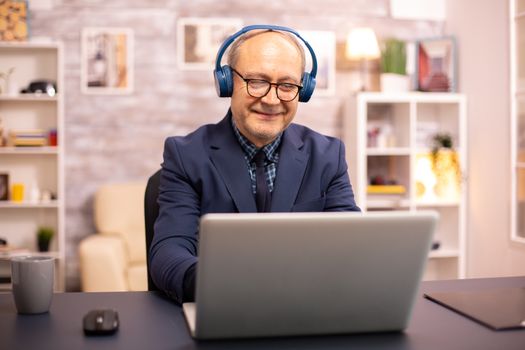 Elderly man in his 60s with headphones on his head
