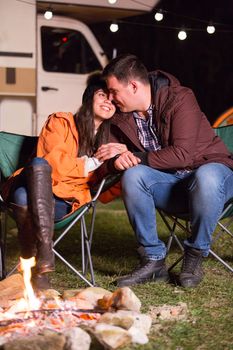 Beautiful couple recreating along campfire in the mountains