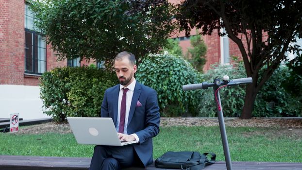 Businessman working on the laptop outdoor, slow motion zoom in