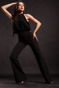 Beautiful fashion model wearing black pants posing in studio