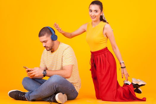 Boyfriend using his phone while girlfriend trying to get his attention