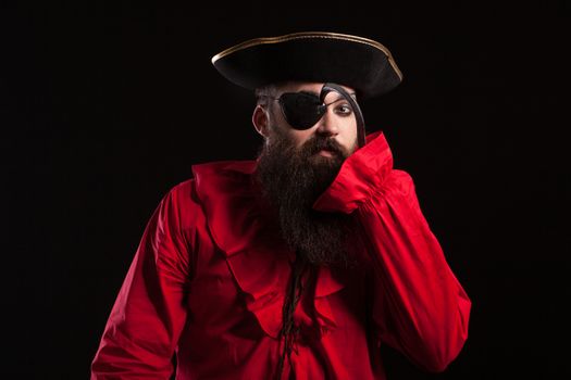 Attractive bearded man in a pirate costume for carnival touching