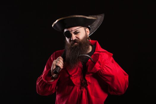 Angry man in a pirate capitan costume for halloween holding and axe on his shoulder