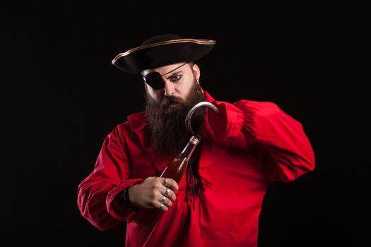 Portrait of a medieval bearded pirate opening a bottle with his hand hook for halloween