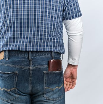 man in jeans and a blue shirt stands with his back