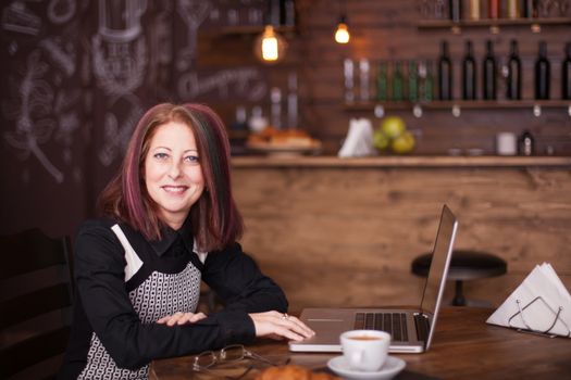 Smiling businesswoman with a laptop in font of her