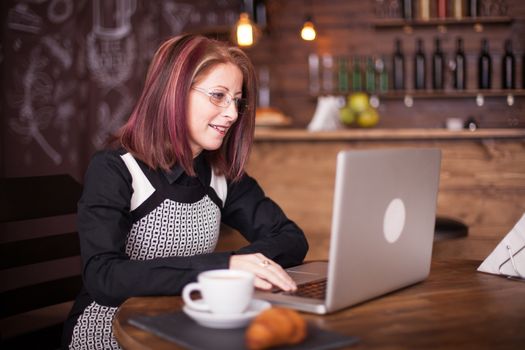 Smiling adult business person working on laptop