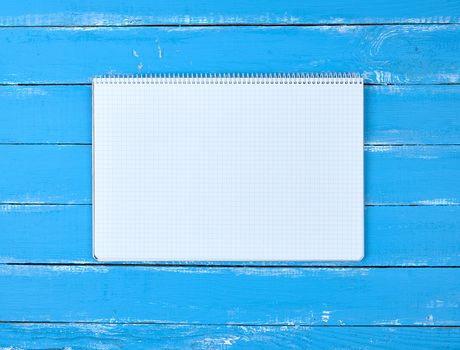 open notebook in a cell on a blue wooden background