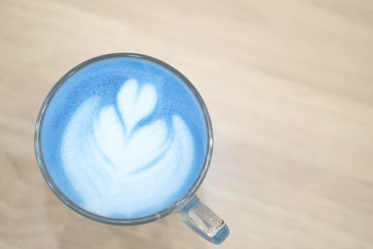 Closeup top view glass of blue milk with latte art tulip shape o