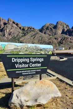 Dripping Springs Visitor Center- sign against a mountain landscape near a park visitor center, New Mexico