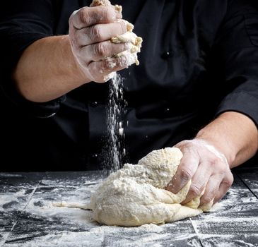 men's hands knead white wheat flour yeast dough 