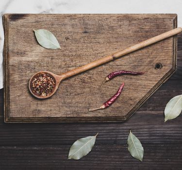wooden spoon with  spices on a cutting board
