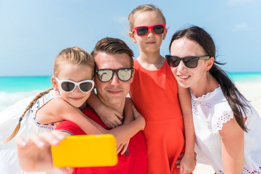 Young beautiful family taking selfie portrait on the beach