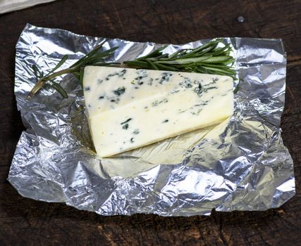piece of cheese with mold roquefort on a piece of foil