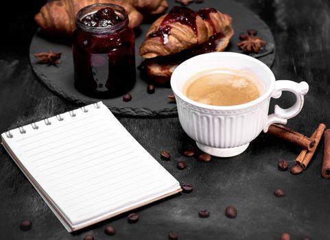  cup with black coffee and an empty paper notebook 