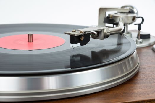 Closeup of turntable with vinyl record on white background