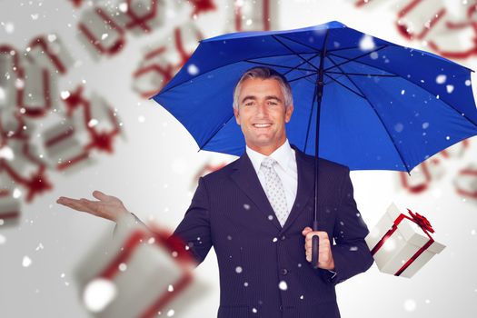 Composite image of smiling businessman holding blue umbrella with hand out