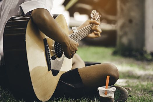 man playing the guitar on the lawn