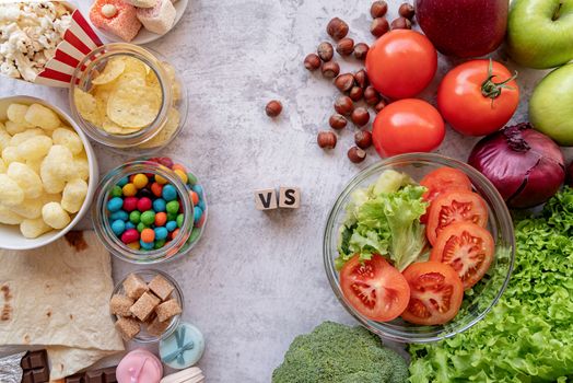 Fruit and vegetables vs sweets and potato fries top view flat lay