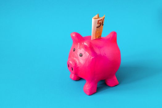 pink papier mache piggy bank with 50 Euros