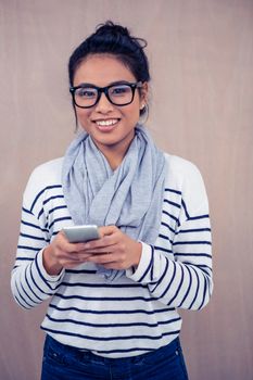 Smiling Asian woman using smartphone and looking at the camera