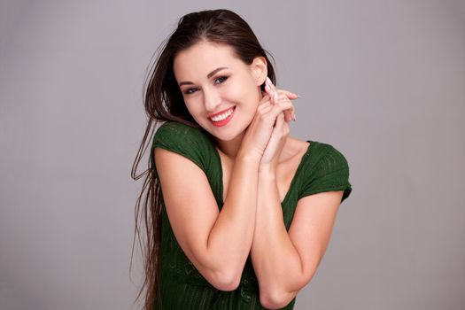 cheerful young woman smiling with hands clasp together