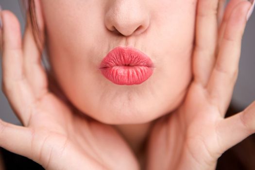 Close up young woman lips kissing